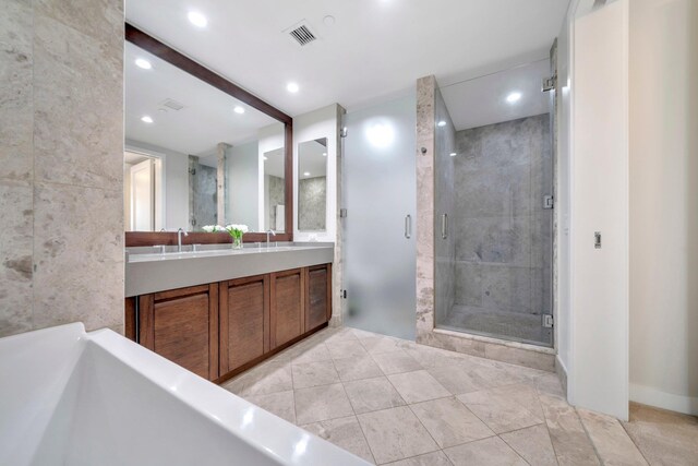 bathroom featuring visible vents, recessed lighting, a shower stall, double vanity, and a soaking tub