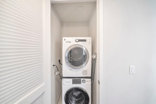 clothes washing area with laundry area and stacked washer / drying machine