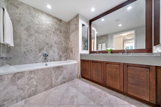 bathroom featuring double vanity, a garden tub, tile walls, and recessed lighting