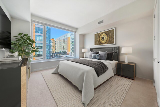 bedroom featuring baseboards, visible vents, and light carpet