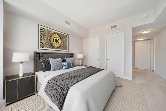 carpeted bedroom featuring visible vents and baseboards