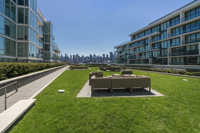 view of home's community with a city view, a yard, and a patio area