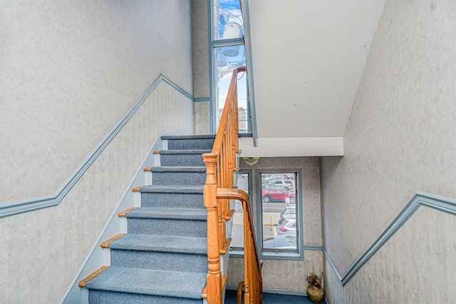 staircase featuring wallpapered walls