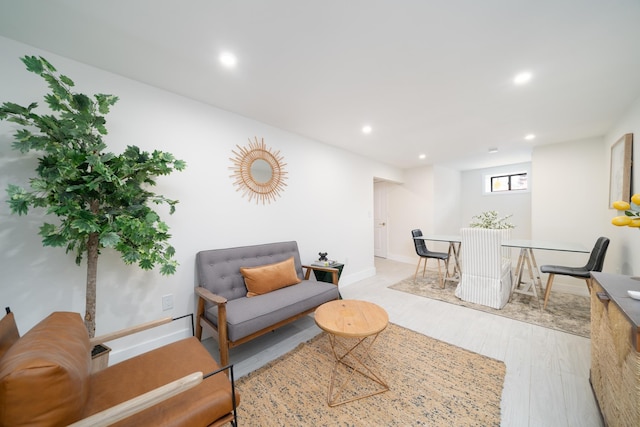 living area with baseboards, wood finished floors, and recessed lighting