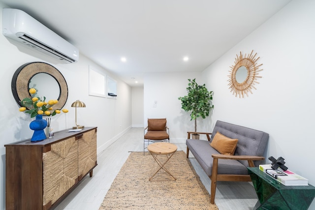 living area featuring light wood-style floors, baseboards, an AC wall unit, and recessed lighting