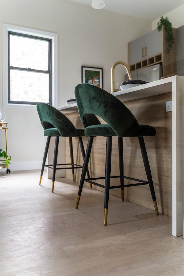 bar with light wood-style floors and baseboards