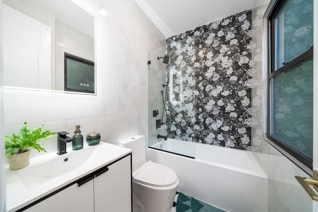 bathroom featuring bath / shower combo with glass door, decorative backsplash, toilet, vanity, and tile walls