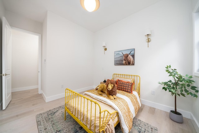 bedroom with light wood-type flooring and baseboards