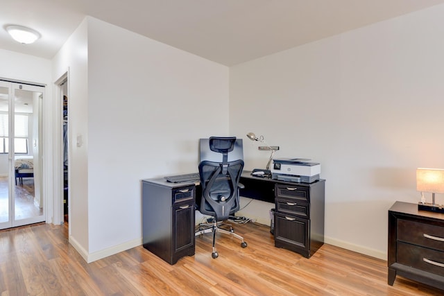 office space featuring baseboards and light wood-type flooring