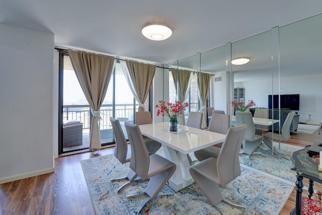 dining space featuring baseboards and wood finished floors