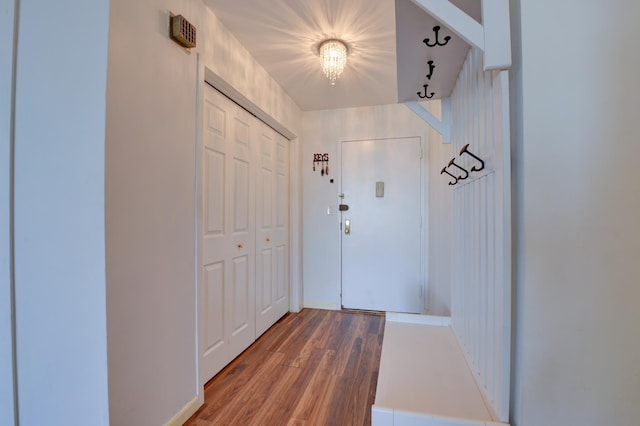 doorway featuring wood finished floors and a notable chandelier