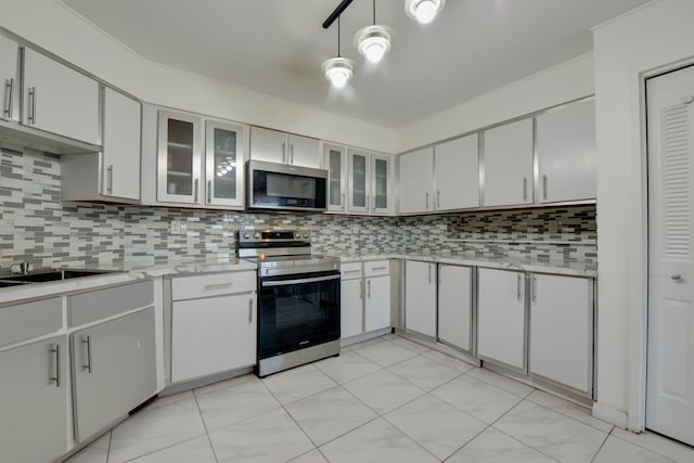 kitchen featuring light countertops, stainless steel appliances, decorative backsplash, and glass insert cabinets