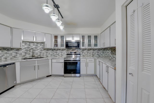 kitchen featuring tasteful backsplash, a sink, white cabinets, glass insert cabinets, and stainless steel appliances