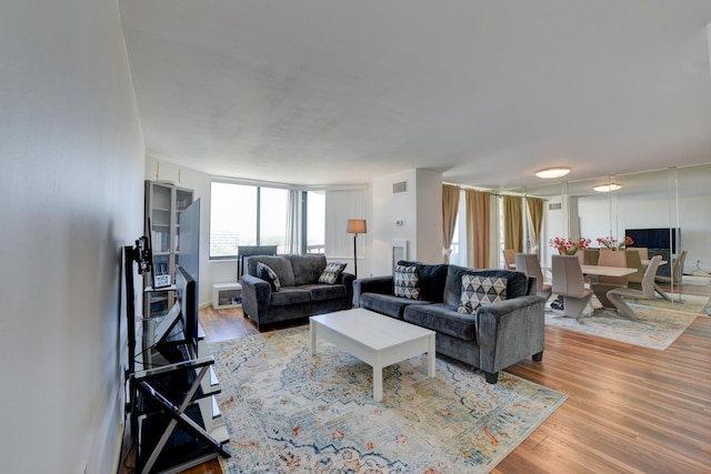 living area featuring visible vents and wood finished floors