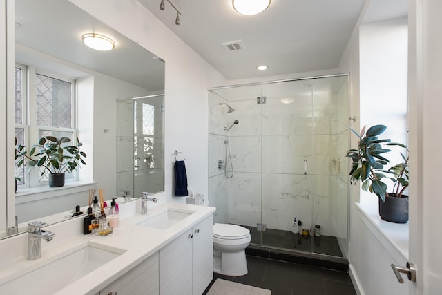 bathroom with an enclosed shower, vanity, tile patterned flooring, and toilet