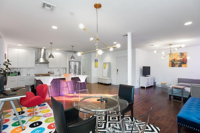 dining room with dark wood-type flooring, sink, and a notable chandelier