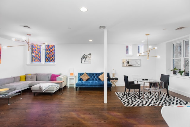 living room with dark wood-type flooring and a notable chandelier