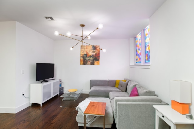 living room with dark wood-type flooring and a notable chandelier