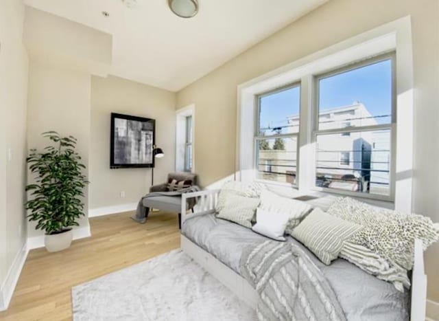 living area featuring light wood finished floors and baseboards