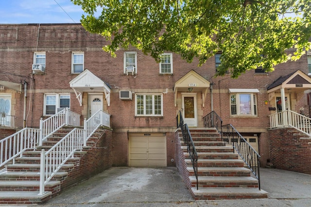 104 W 52nd St, Bayonne, NJ 07002 - townhome / multi-family property with driveway, a garage, brick siding, and stairs