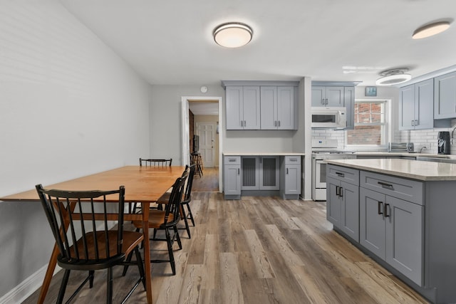 104 W 52nd St, Bayonne, NJ 07002 - kitchen with white appliances, gray cabinetry, and wood finished floors