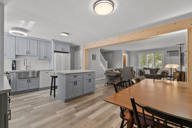 104 W 52nd St, Bayonne, NJ 07002 - kitchen with gray cabinets, white appliances, backsplash, and a breakfast bar area