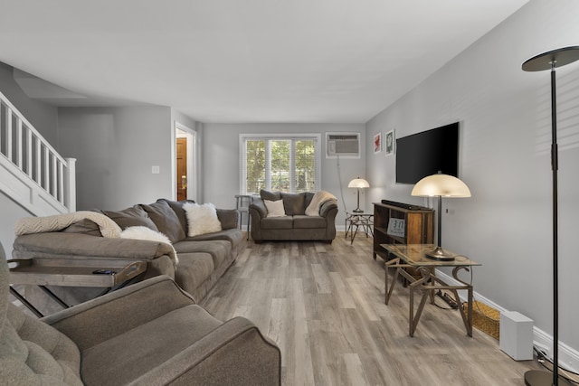 104 W 52nd St, Bayonne, NJ 07002 - living area featuring an AC wall unit, light wood finished floors, and stairs