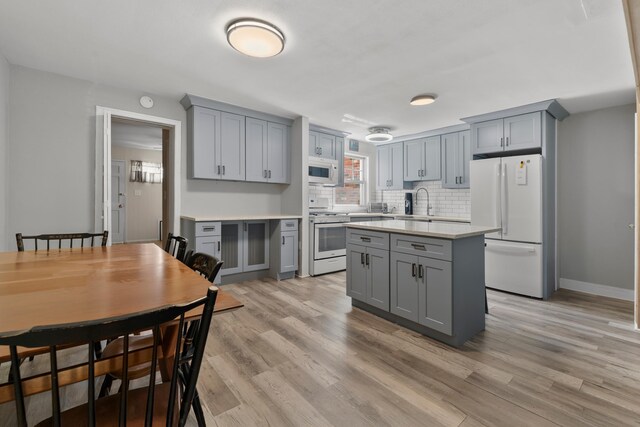 104 W 52nd St, Bayonne, NJ 07002 - kitchen featuring white appliances, gray cabinets, light countertops, and light wood-type flooring