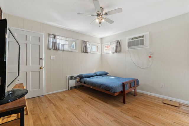 104 W 52nd St, Bayonne, NJ 07002 - bedroom featuring light wood-style floors, an AC wall unit, radiator, and a ceiling fan