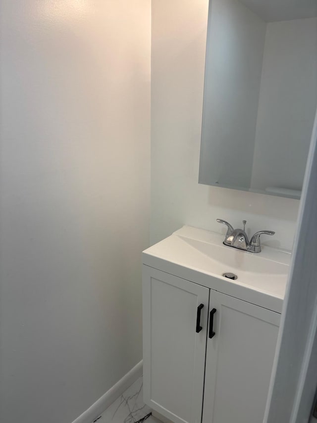 bathroom with baseboards, marble finish floor, and vanity
