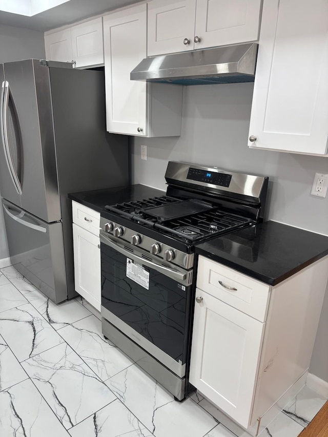 kitchen with stainless steel gas range, dark countertops, under cabinet range hood, and marble finish floor