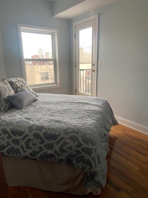 bedroom featuring multiple windows and dark wood-type flooring