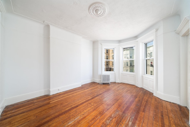 27 48th St, Weehawken, NJ 07086 - empty room featuring radiator heating unit and hardwood / wood-style floors