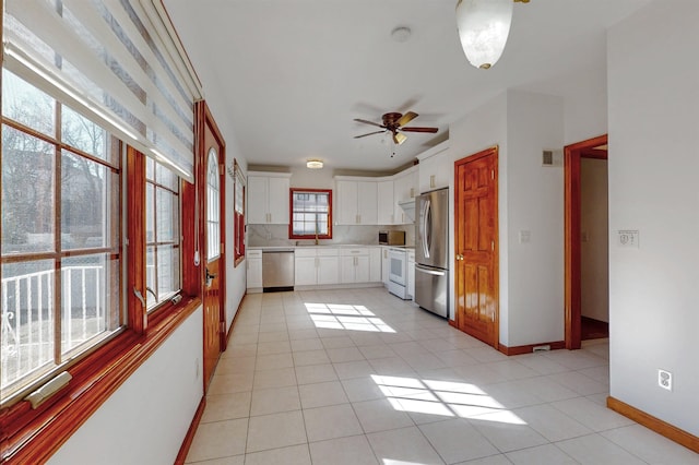 kitchen with light countertops, light tile patterned floors, baseboards, and stainless steel appliances