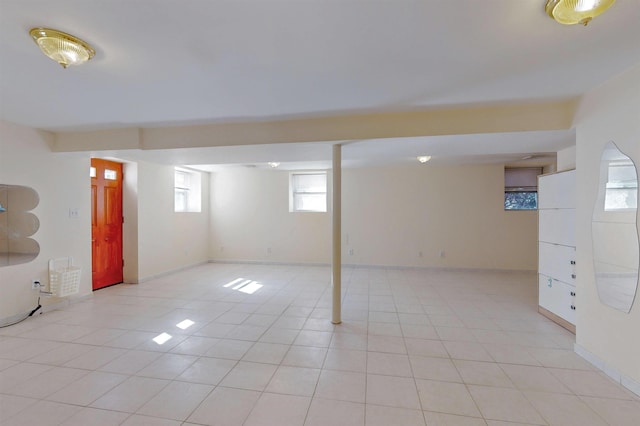 basement featuring light tile patterned floors and baseboards