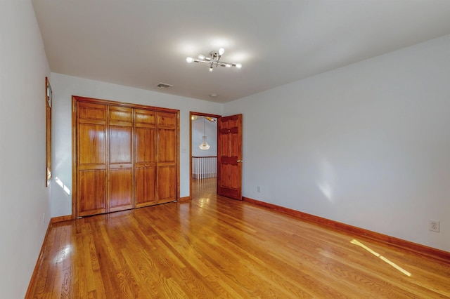 unfurnished bedroom with light wood-type flooring, baseboards, and visible vents