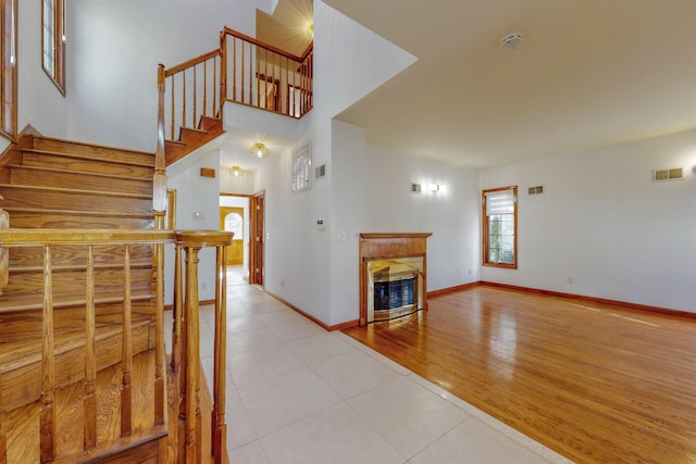 stairs featuring tile patterned flooring, a fireplace, visible vents, and baseboards