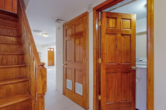 corridor with light tile patterned floors, visible vents, and stairway