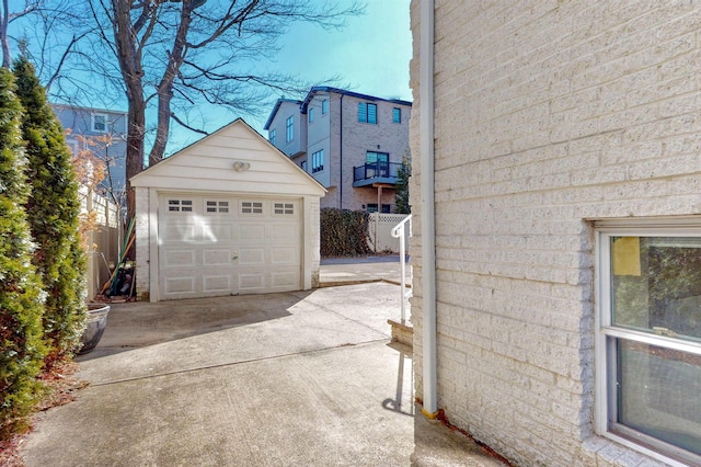 detached garage featuring fence and driveway