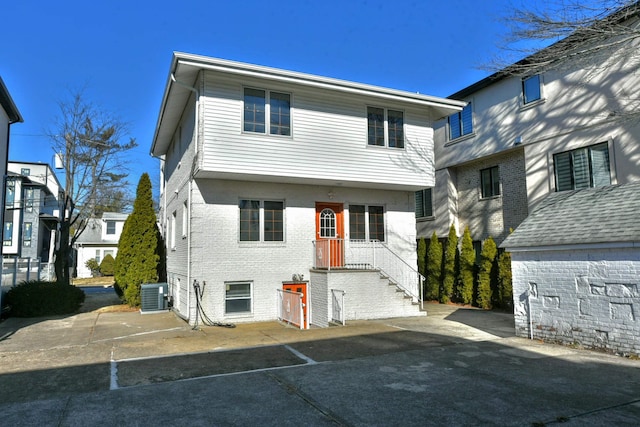 view of front of home with brick siding and central AC