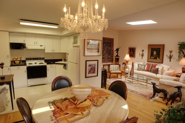 dining area featuring sink, a notable chandelier, and light wood-type flooring