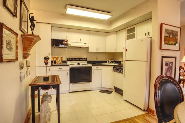 kitchen featuring white cabinetry, white appliances, sink, and light tile patterned floors