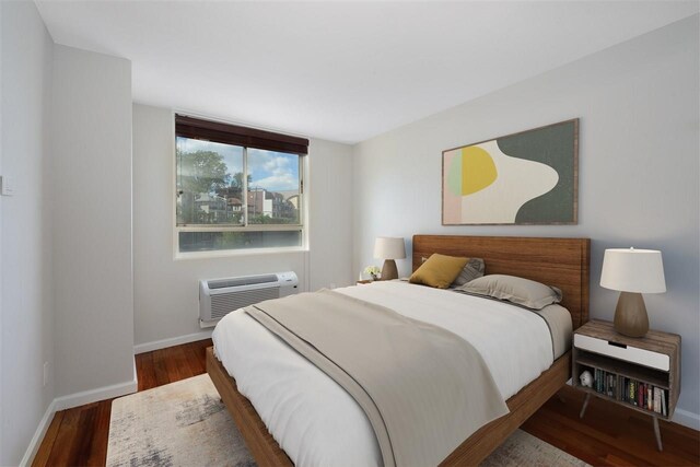 100 Manhattan Ave Unit 205, Union City, NJ 07087 - bedroom with a wall unit AC, baseboards, and wood finished floors