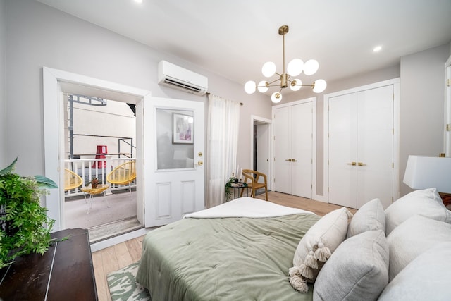 bedroom featuring a wall mounted AC, light wood-style floors, a chandelier, multiple closets, and recessed lighting