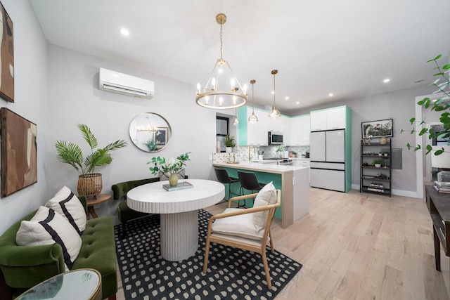 dining area featuring an AC wall unit, recessed lighting, light wood-style flooring, and a notable chandelier