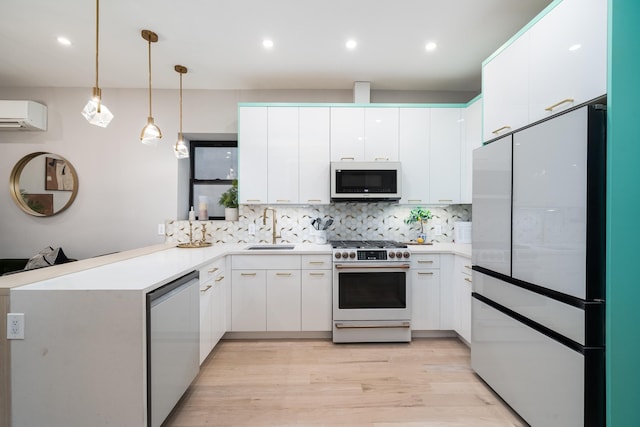 kitchen with white appliances, white cabinets, a wall unit AC, a peninsula, and a sink