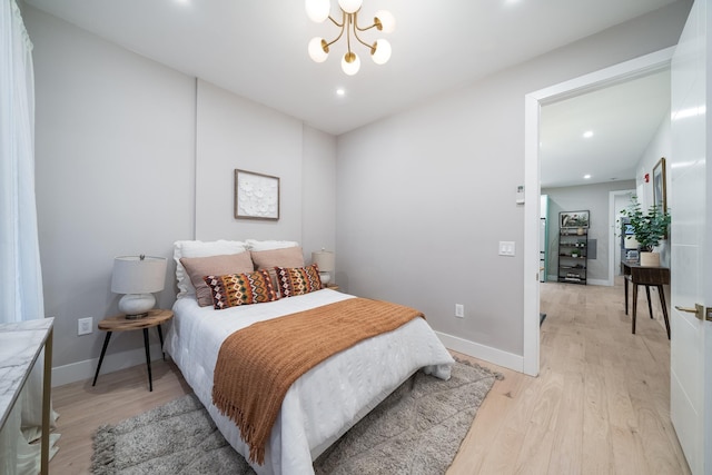 bedroom with light wood-style floors, recessed lighting, baseboards, and an inviting chandelier