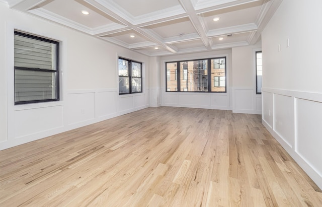 spare room featuring beam ceiling, light wood-type flooring, crown molding, and coffered ceiling