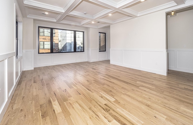 spare room featuring beam ceiling, light hardwood / wood-style floors, ornamental molding, and coffered ceiling