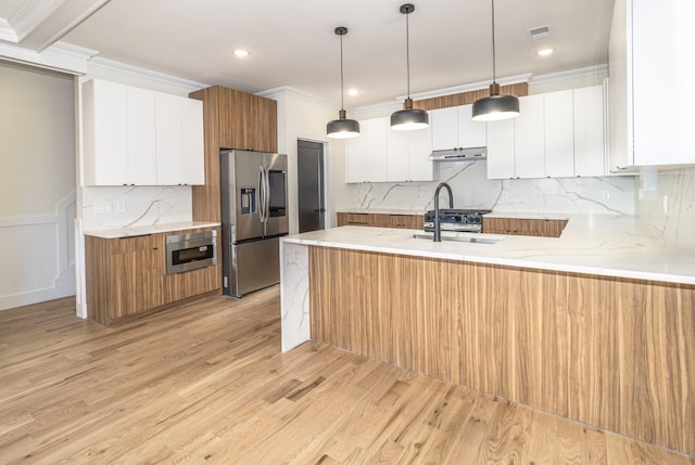 kitchen featuring light hardwood / wood-style flooring, stainless steel fridge, decorative light fixtures, white cabinets, and ornamental molding